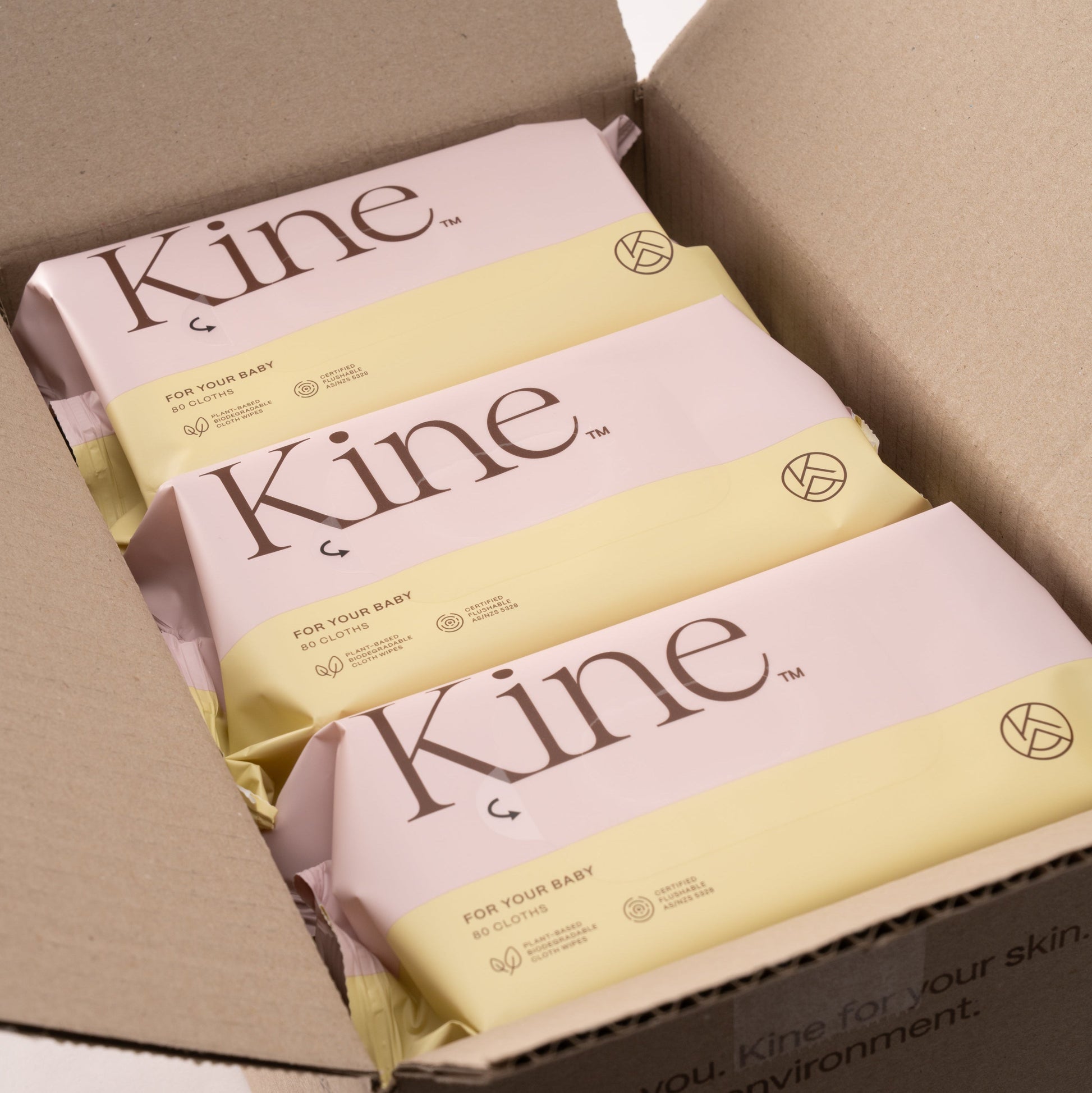 Kine products in a cardboard box on a white background. Hypoallergenic baby wet wipes Australia, plant-based wipes, flushable wipes, biodegradable flushable wipes, eco-friendly wet wipes. 100% plant-based wipes